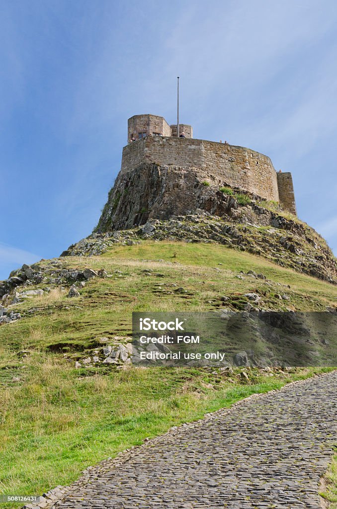 Lindisfarne Castle Holy Island, Northumbria, England - August 14th, 2014;  Tourists enjoy the summer sunshine and the views from the battlements of Lindisfarne Castle a major tourist attraction in Northumberland Architecture Stock Photo