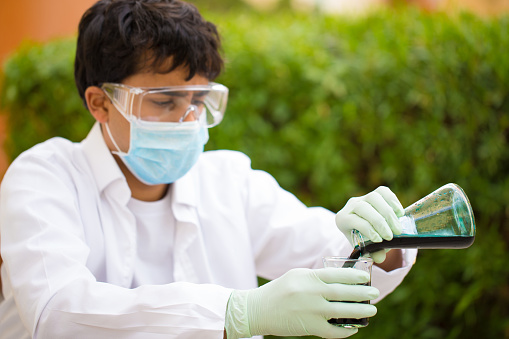 Young Science Student conducting an experiment with toxic chemicals in an outdoor setting.
