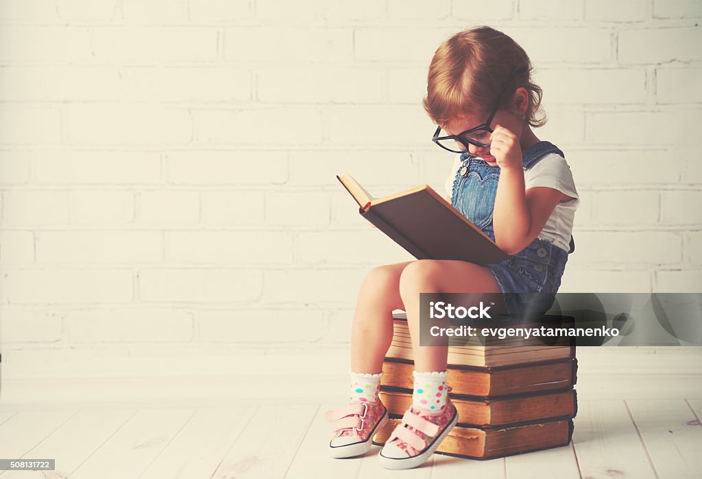 Enfant fillette avec des lunettes de lecture d'un livre - Photo de Enfant libre de droits