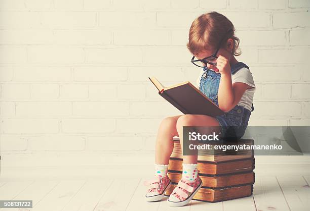 Photo libre de droit de Enfant Fillette Avec Des Lunettes De Lecture Dun Livre banque d'images et plus d'images libres de droit de Enfant