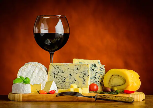 One glass of red wine and some soft-cheese, gorgonzolla, camembert and food