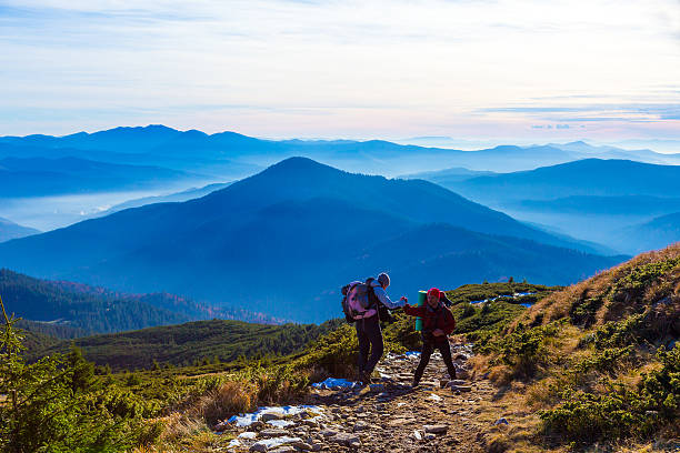 istock Two Hikers helping each other on Mountain Trail 508134942