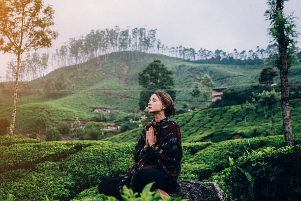 Caucasian woman meditates on the tea plantation 