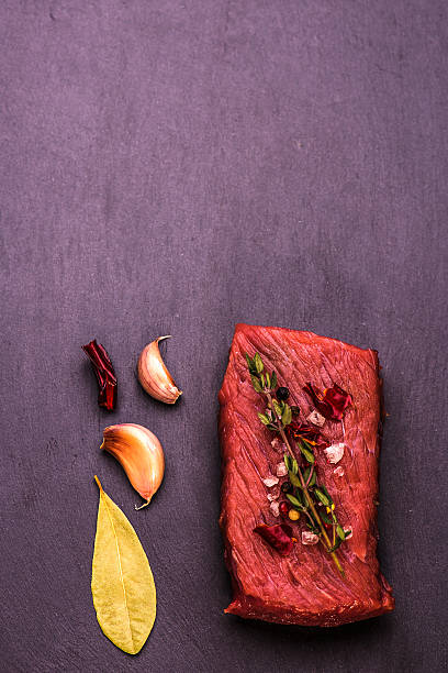 istock Raw Beef Steak, salt, pepper, garlic, rosemary  on black  background. 508137176