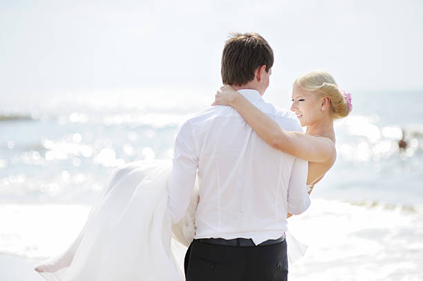 istock Bride and groom walking by the sea 508138648