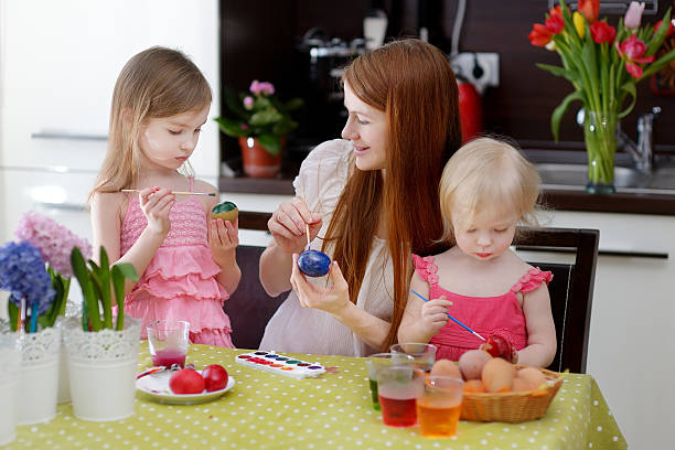 istock Mother and her daughters painting Easter eggs 508138770