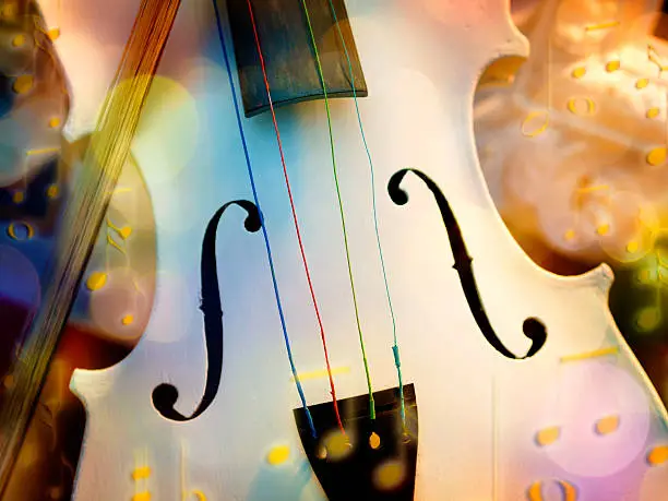 Image of a white violin with fiddlestick and bokeh