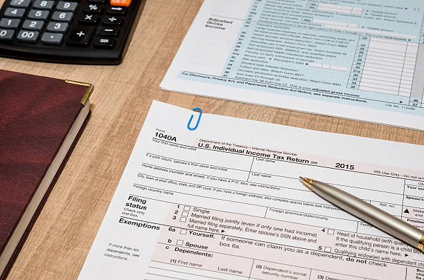 istock 1040 Tax Form with calculator and pen 508139694
