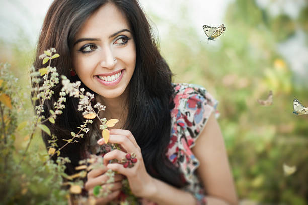 nahaufnahme der schöne glückliche junge frau in der natur mit grün - india women butterfly indian ethnicity stock-fotos und bilder