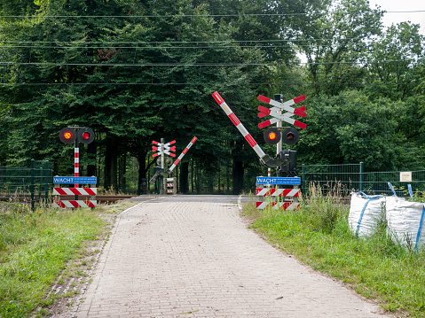 rural road with railway crossing in the Netherlands closing for a train
