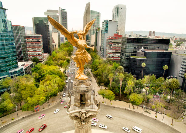 Nocturnal view of the Benito Juarez Monument in the Mexico City downtown. The photo was taken from the other side of the street, so in the first plane you can see the crowd and, a little behind, the lights of traffic on the centric Juarez Avenue.