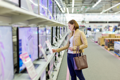 Mujer Elige un televisor en la tienda photo