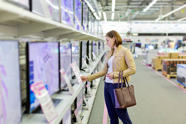 donna sceglie la tv nel negozio - attrezzatura elettronica foto e immagini stock