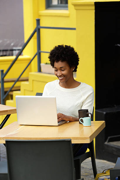 istock Happy african woman using laptop at cafe 508154764