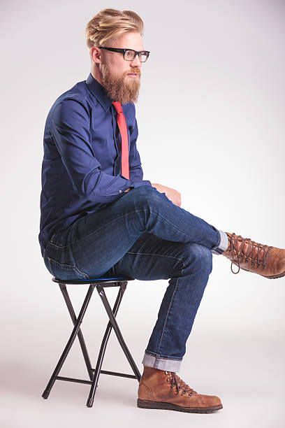 istock young casual man sitting on a stool 508157686