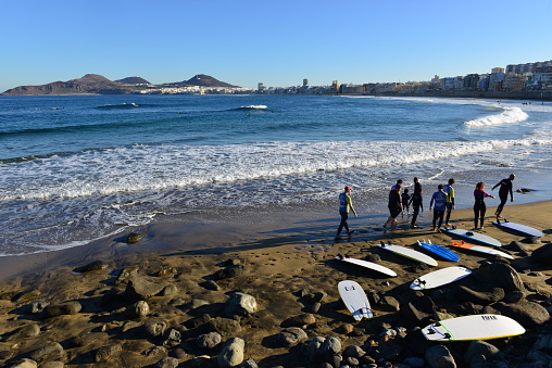 Gran Canaria, Spain, - December 19, 2015: Surfers warming up on the cities beach of Playa De Canteras in the morning,