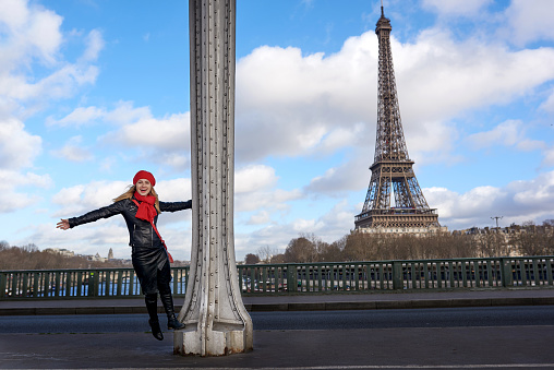 happy woman enjoying her city break to Paris, laughing and spinning around column,Eiffel Tower in background.