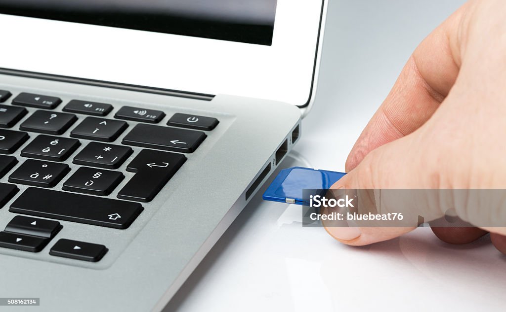 Inserting SD Card into a laptop computer USB Stick Stock Photo