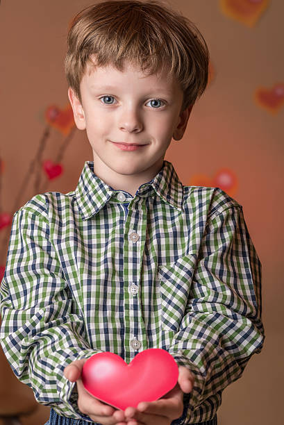 istock Boy gives a pink heart on Valentines Day. 508162276