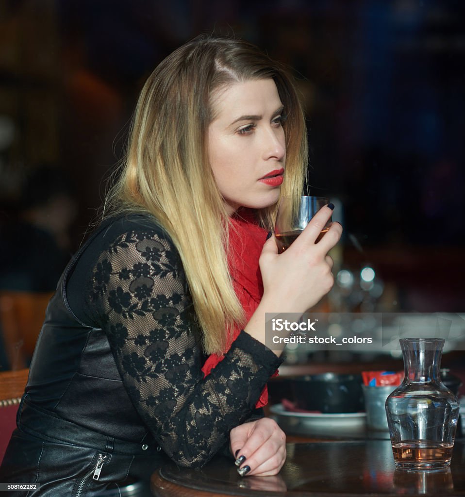enjoy my wine glass side view of attractive woman drinking glass of wine inside restaurant, looking away.lifestyle concept. 25-29 Years Stock Photo