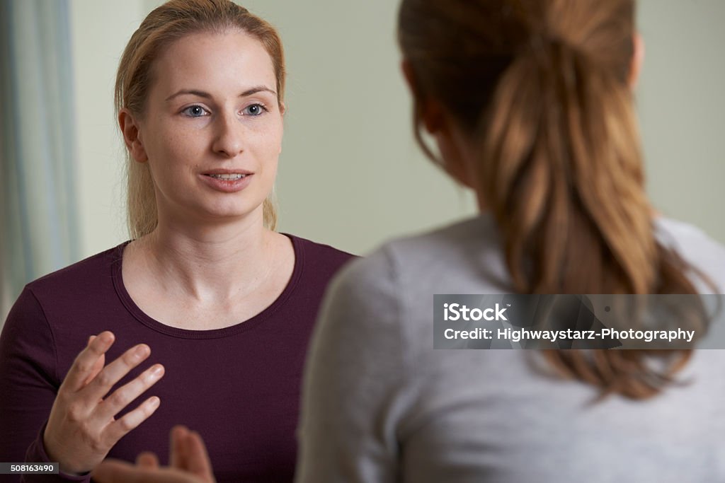 Young Woman Discussing Problems With Counselor Discussion Stock Photo