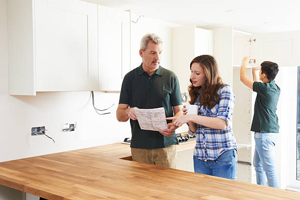 istock Woman With Carpenter Looking At Plans For New Kitchen 508164286