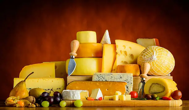 Cheese and food on wooden table. Different types of cheese