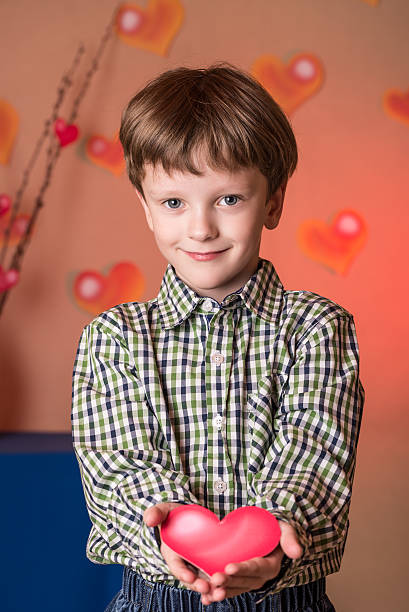 istock Boy gives a pink heart on Valentines Day. 508166114