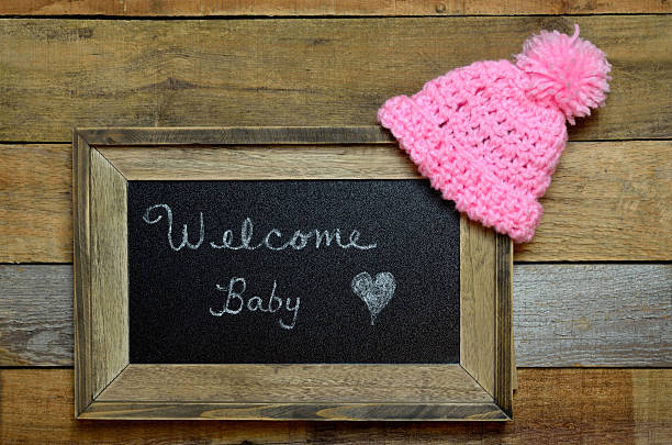 Welcome baby notice with pink knit cap stock photo
