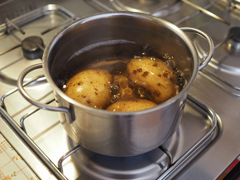 Boiling potatoes in a saucepan on gas cooker