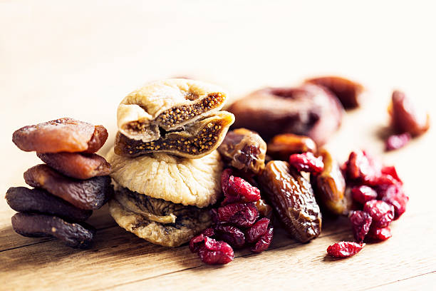 dried fruit like dried figs, cranberries and dates on wooden background