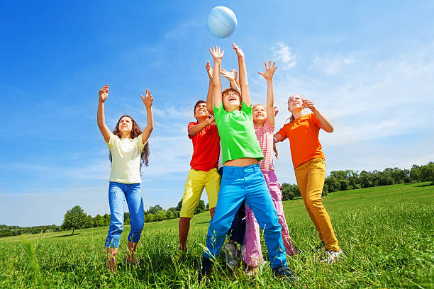 istock Happy kids catching ball in air outside 508169405