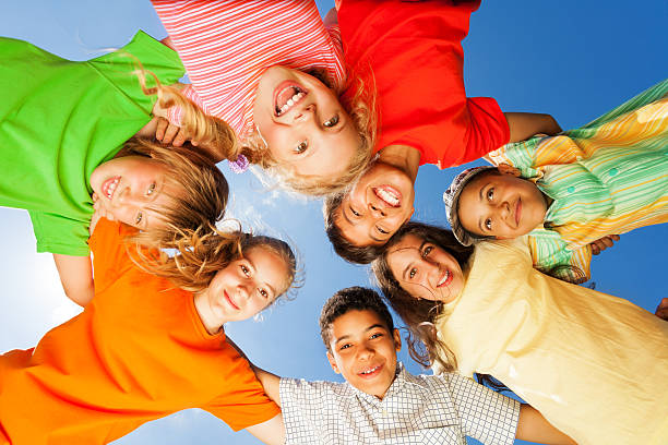 istock Happy kids close in circle on sky background 508169423