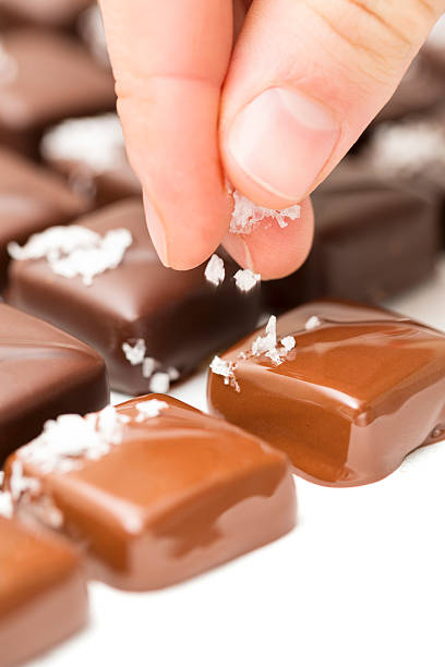 Chocolate making: putting salt flakes on caramel truffles