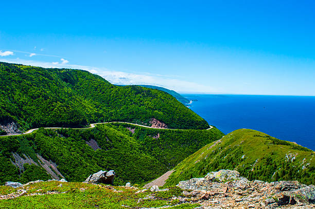 Mountain, ocean, and road This is an image of a beautiful mountain road with the ocean and sea as the background. cabot trail stock pictures, royalty-free photos & images