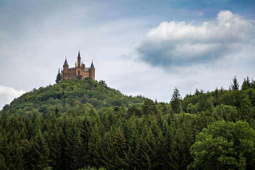 Hohenzollern Castle in Germany on a wooded mountain.
