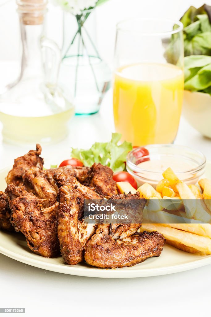 Alitas de pollo con salsa picante papas fritas y francesa - Foto de stock de Ala de animal libre de derechos