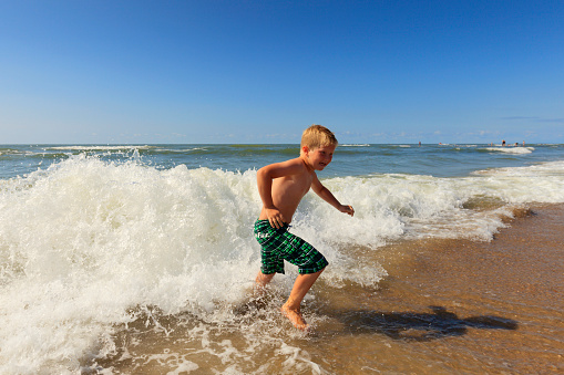 young boy enjoying the waves along the coast