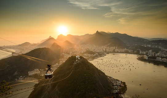 Sunset seen from Sugar Loaf Mountain (Morro do Pão de Açúcar), Rio de Janeiro, Brazil. In the foreground, the Sugar Loaf cable car (Bondinho) and Urca Hill (Morro da Urca).