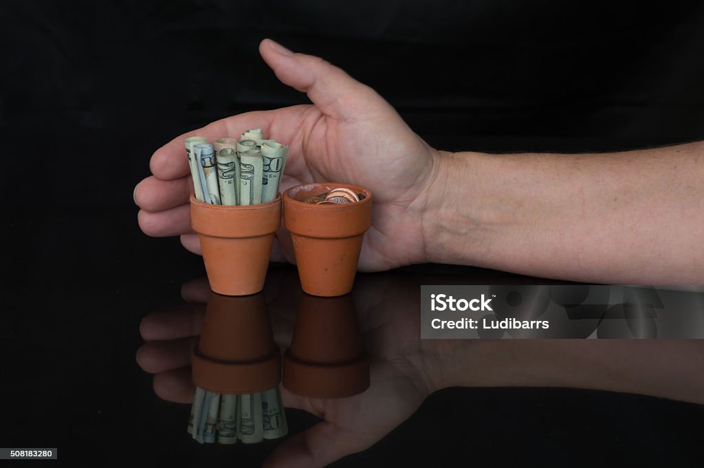 Money Being Held in a Terracotta Pot Money in a terracotta pot 2000-2009 Stock Photo