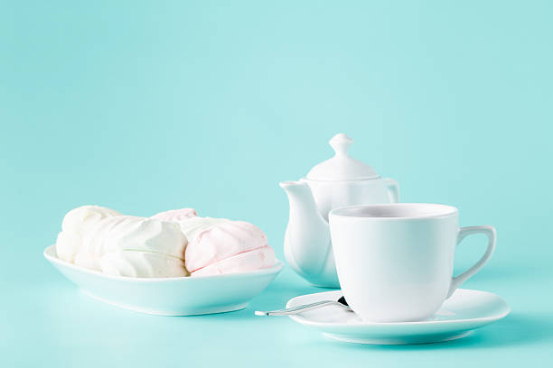 istock Delicate meringues, marshmallows and cup of english tea on white 508183666