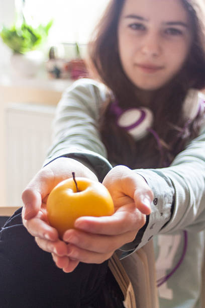 istock Girl holding a yellow apple 508184410