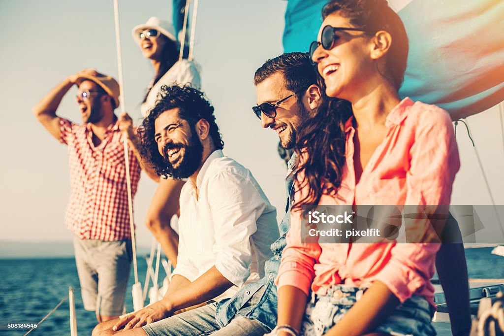 Happy friends on a yacht Young people having a summer vacation on a yacht. Friendship Stock Photo