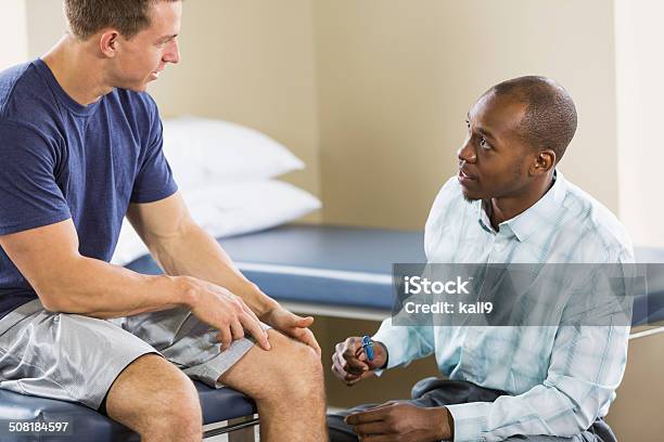 Physical Therapist Examining Patient Stock Photo - Download Image Now - Examining, Physical Therapy, Discussion