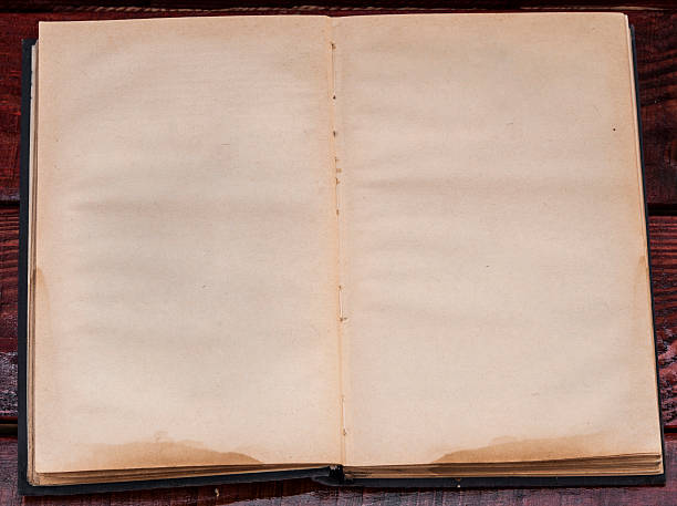 istock Vintage book, open, on old wooden table. 508186408