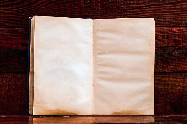 istock Vintage book, open, on old wooden table. 508186542