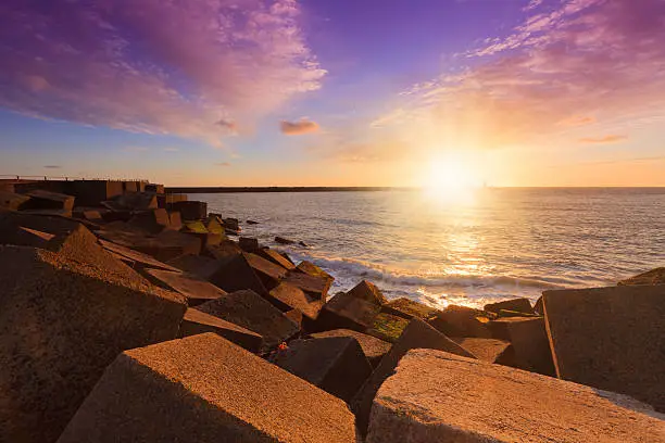 colorful sunset over the jetty at the entrance of the harbor at Scheveningen; Scheveningen Netherlands