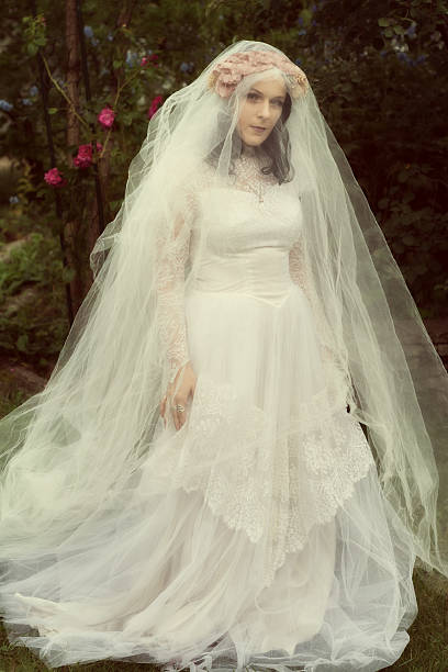 istock Veiled bride in garden, retro edit with warm tones. 508188498