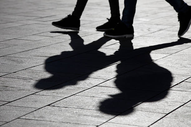istock sun casting shadow over two people walking on the street 508189186