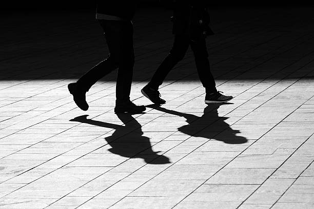 istock sun casting shadow over two people walking on the street 508189226